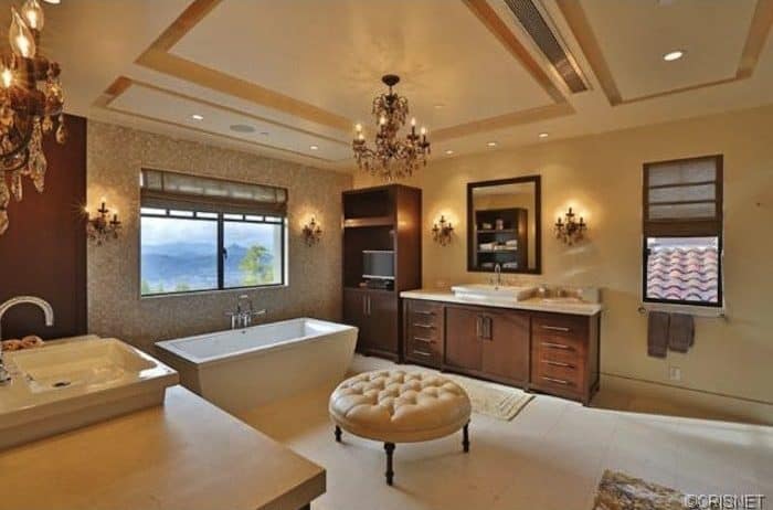 这款主要浴室在整个房间里拥有一套优雅的照明。独立式浴缸与容器水槽一起看起来很完美。天花板看起来绝对华丽。