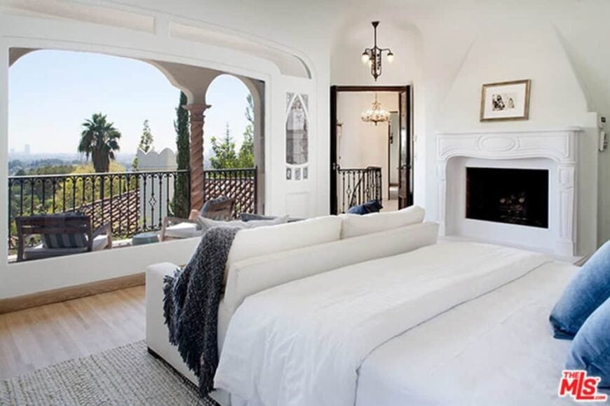 漂亮的白色主卧室，带阳台和壁炉。