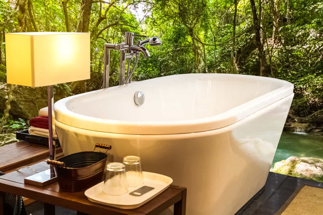 一个大型独立浴缸设置在户外的财产。当你泡在浴缸里时，你可以看到令人惊叹的自然景色。