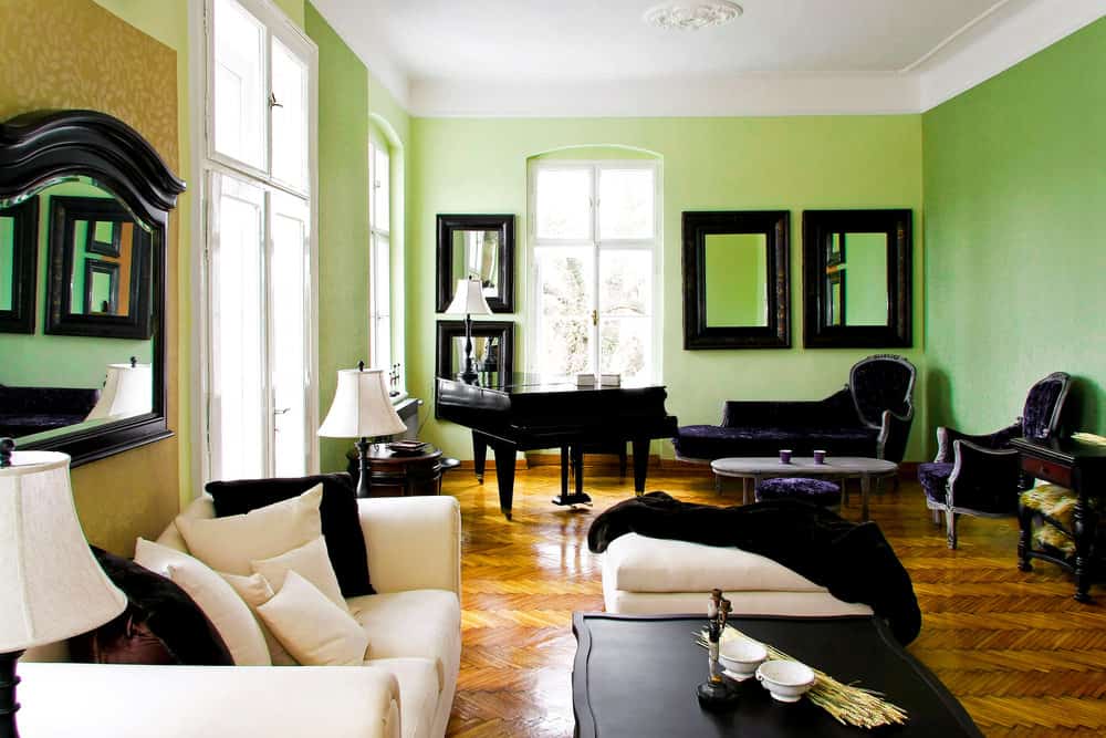 客厅里有两面绿色的墙壁，角落里有一架大钢琴，看起来很优雅。