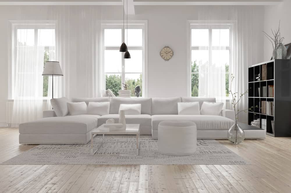 镜头聚焦在客厅硬木地板上的白色大沙发上。