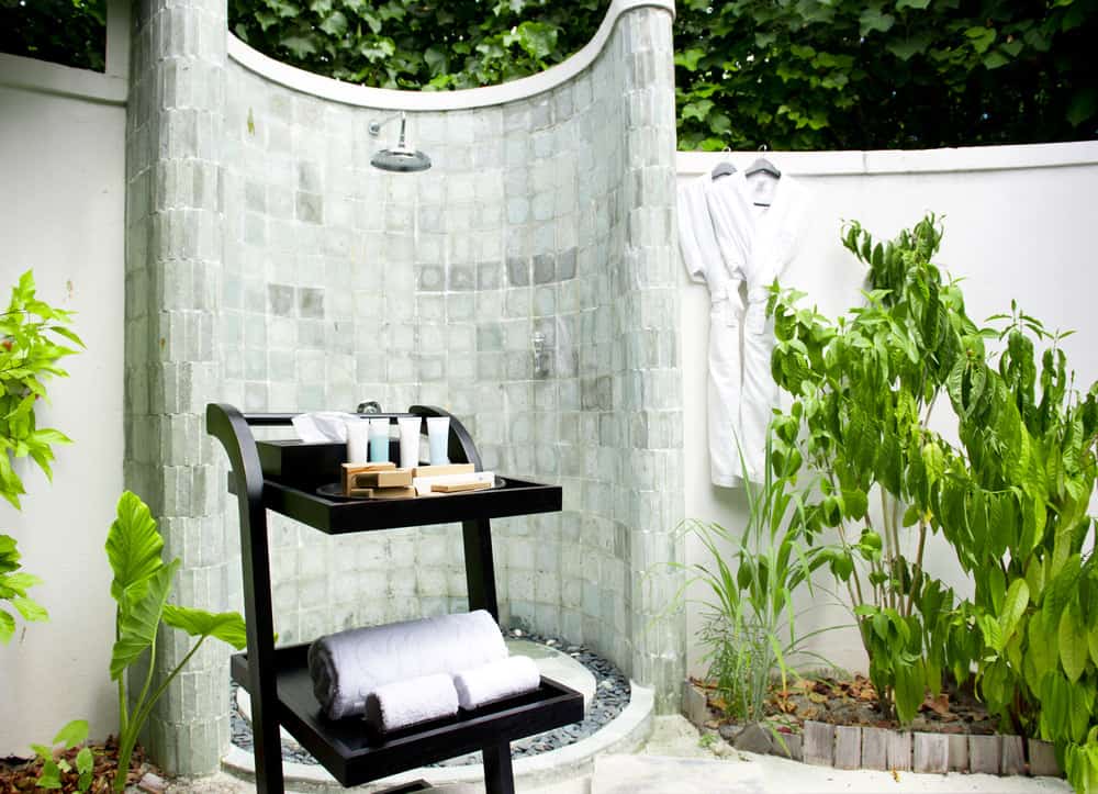 圆形室外淋浴由迷人的瓷砖制成，设置在物业的花园区域。