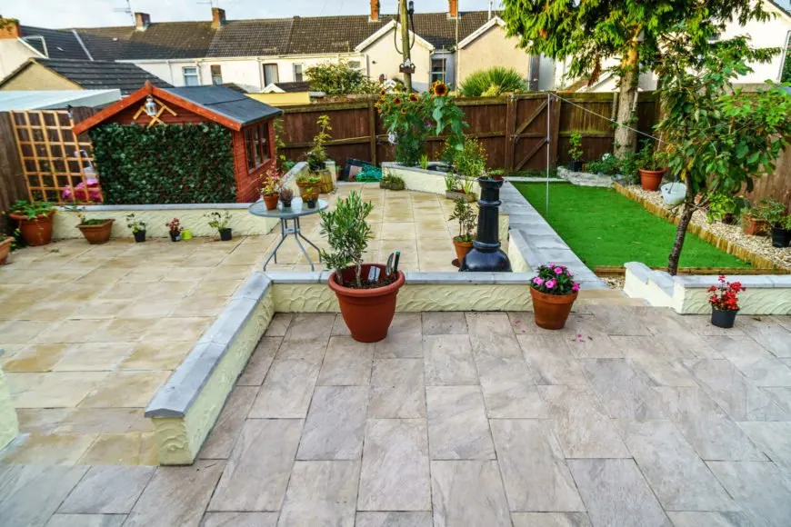 大庭院砖瓷砖地板和一个有趣的草坪区域。