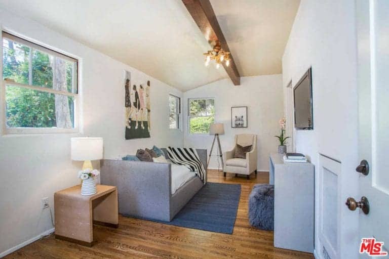 家庭娱乐室拥有舒适的沙发和墙上的电视，硬木地板。