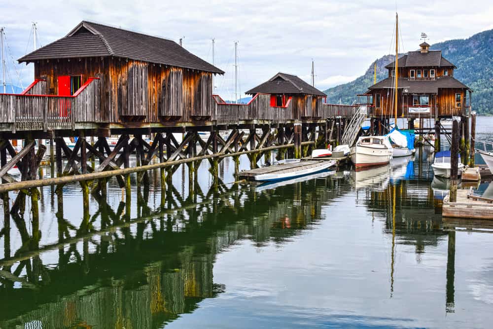 3房屋建在一个长码头港口。房子用木头做的。渔船包围家园。