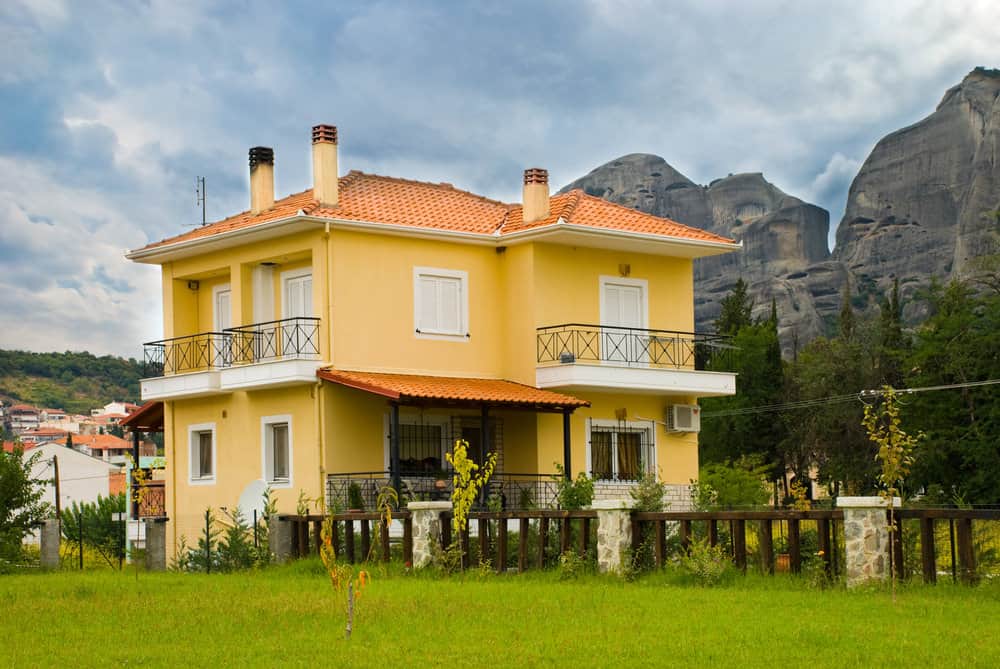 欧洲大陆的黄色住宅，红色屋顶，可以看到雄伟的山脉。