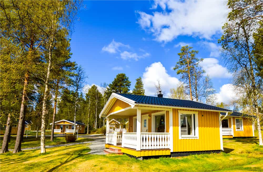 小一层黄色小屋，在乡村有小前廊和轻微的山墙屋顶。