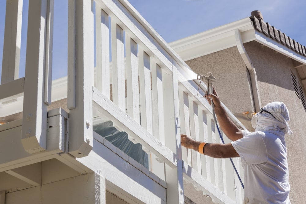 专业的房屋油漆工为阳台栏杆喷漆。