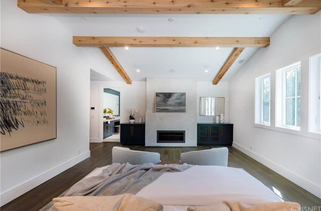 主卧带独立浴室和一座壁炉。这间卧室的特色是硬木地板和白色墙壁，以及带有外露横梁的白色天花板。