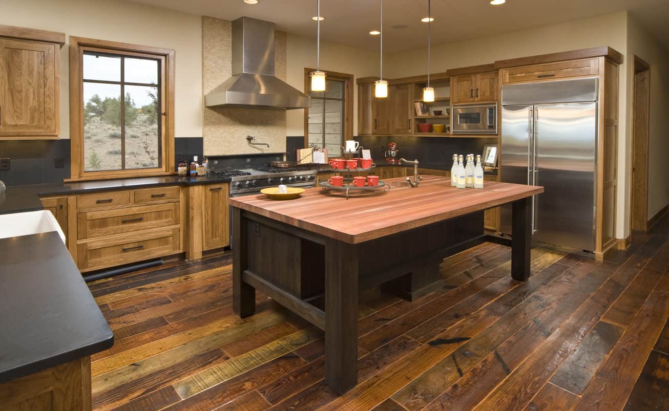 乡村厨房，木制橱柜，乡村木地板，和一个木制厨房岛。