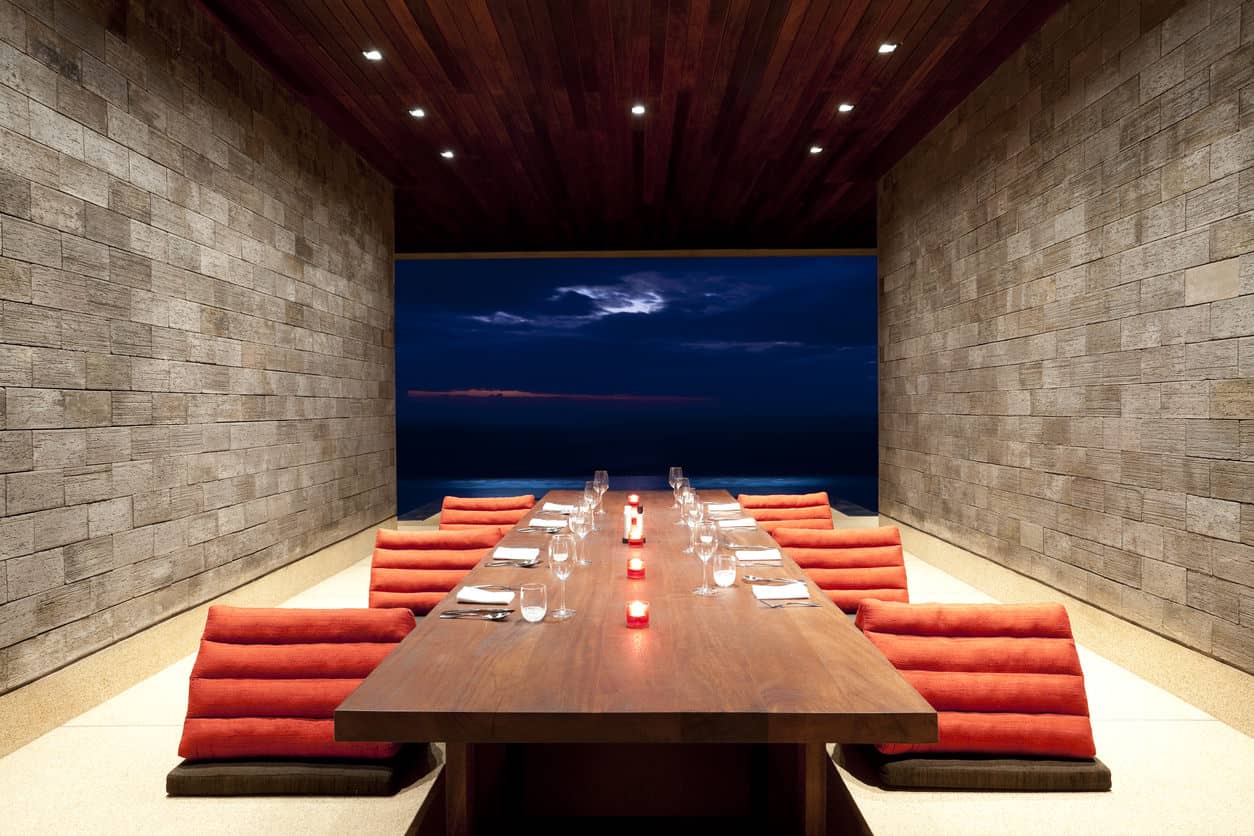 这是一间简单而时尚的餐厅，砖墙和装有嵌入式灯的木板天花板。它有独特的椅子和一张面对壮丽景色的长餐桌。
