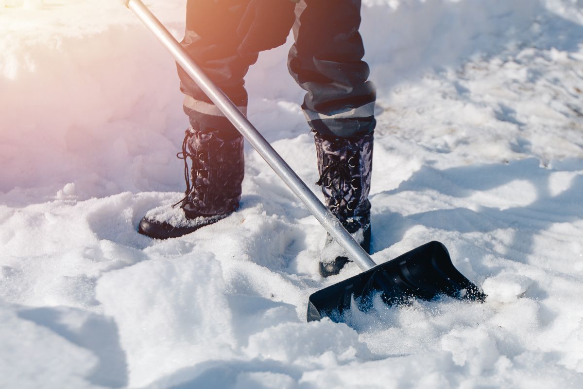 一个穿着靴子的人在铲雪。