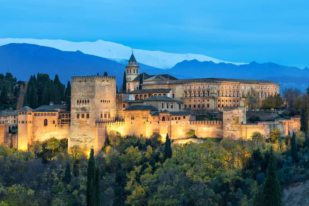 阿尔罕布拉，中世纪摩尔人的堡垒，被秋天的黄树包围，在西班牙安达卢西亚格拉纳达的夜晚被照亮。