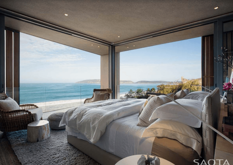一个现代化的主卧室，有一张大床和令人惊叹的海景。