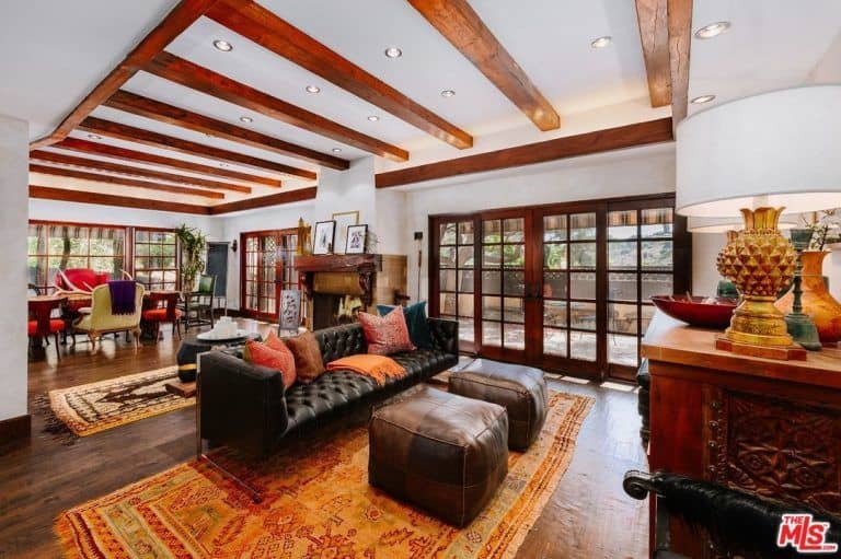 客厅以优雅的横梁、天花板和地毯为特色，沿着硬木地板和壁炉铺设。