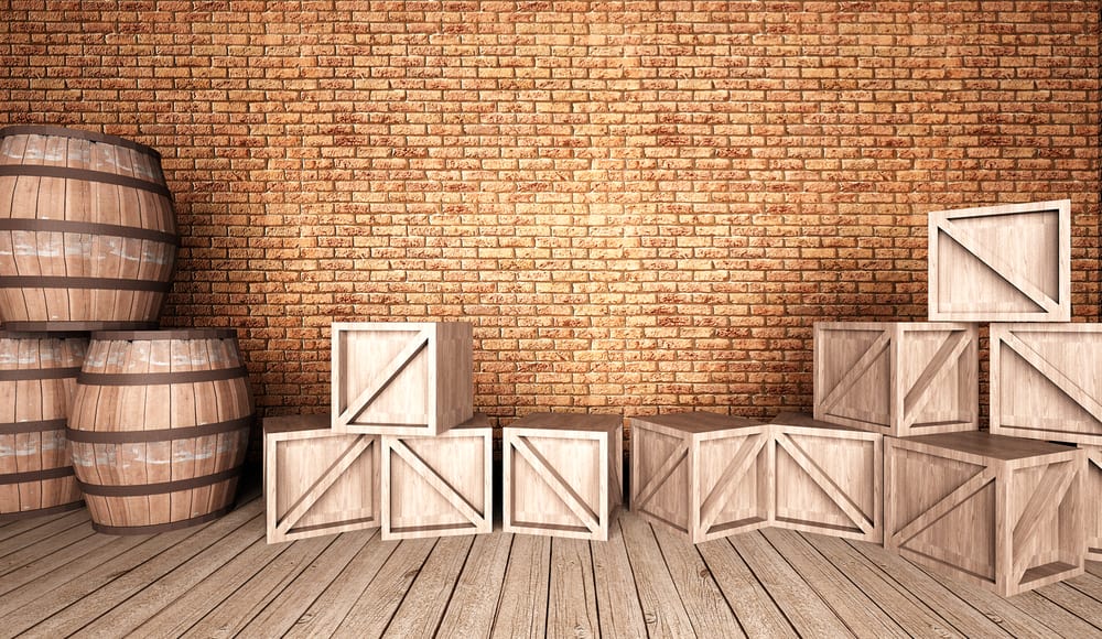 木桶和板条箱放在木地板上，靠着砖墙。