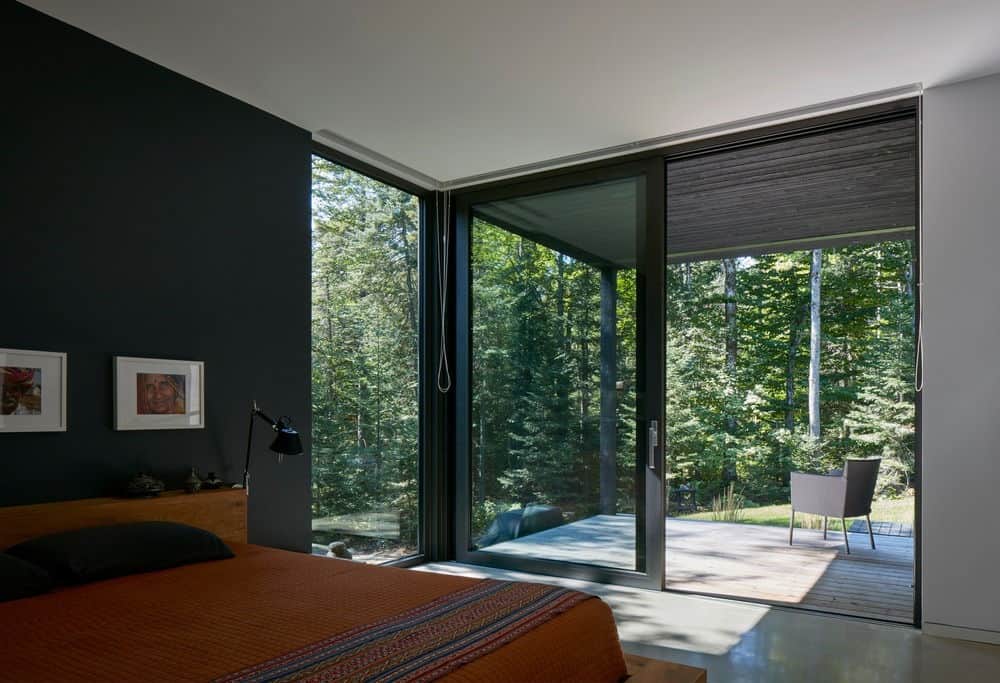 主卧室有漂亮的黑色墙壁和混凝土地板。它有一扇玻璃门，通往露台，在那里你可以放松和放松与雄伟的森林的氛围。