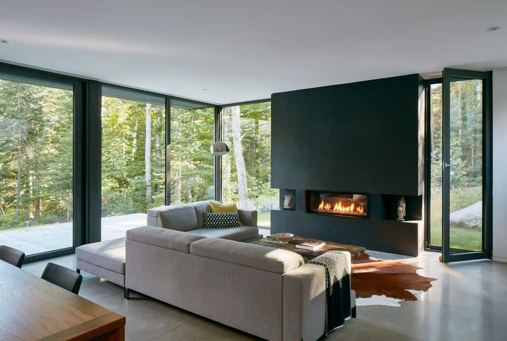 现代风格的客厅，灰色沙发套和黑色壁炉。这块质朴的地毯看起来很漂亮。