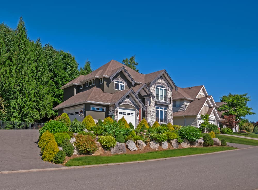 西温哥华(West Vancouver)的住宅，带有短u形车道，穿过前门，延伸到前面和侧面的车库。