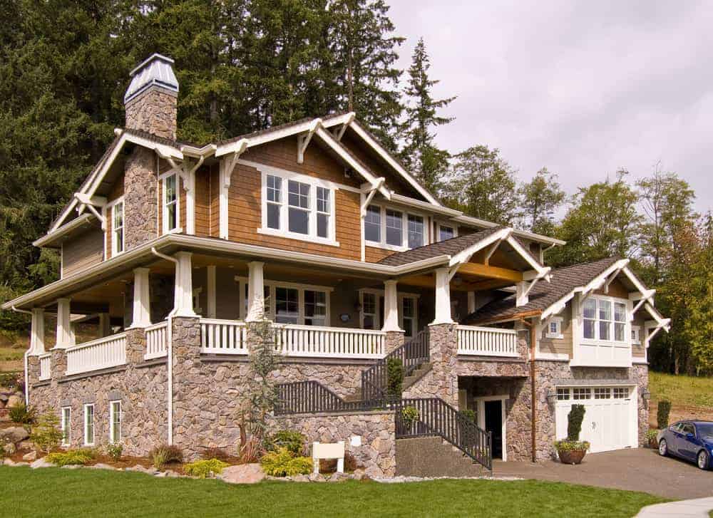 大型山坡住宅，天然木壁板与白色装饰的石头相结合。这是一个宏伟的家，尤其是它是建立在坚固的石头基础上的。