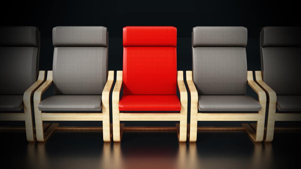 红色的现代椅子在一排灰色的现代椅子中间。
