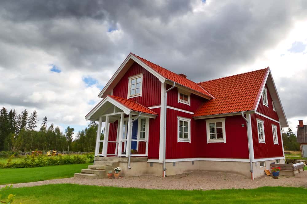 另一个红白相间的瑞典乡村住宅，红瓦屋顶。这所房子坐落在一个大的开放土地上。