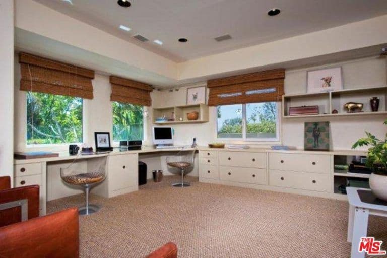 家庭办公室有两张内置办公桌和多个橱柜，以及配有高档百叶窗的玻璃窗。