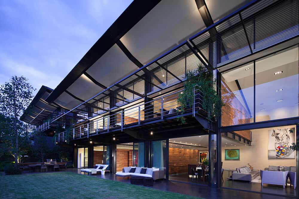 由Grupo Arquitectura设计的现代钢和玻璃大厦，有3层玻璃，几乎延伸到这座巨大的住宅的整个长度。