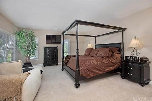 卧室设有一张特大号床和地毯地板，还有一个休息区、电视和一座壁炉。