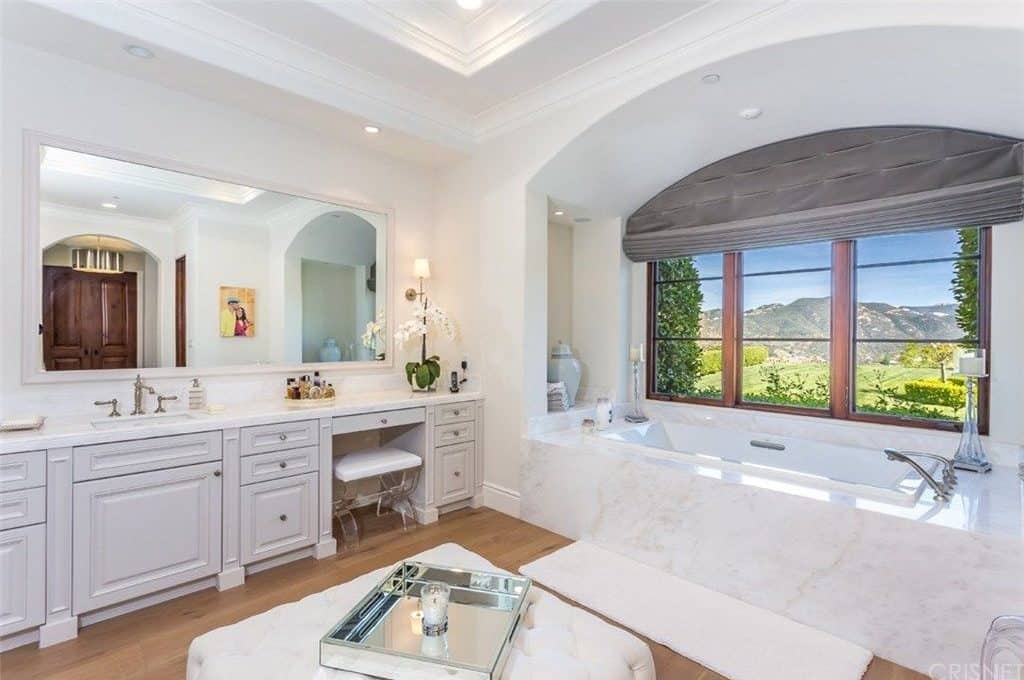 浴室的另一个景观是靠近窗户的角落浴缸，可以俯瞰美丽的室外区域。