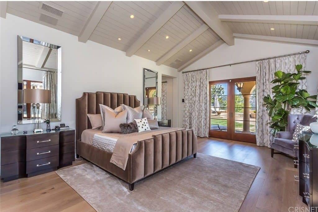 卧室拥有一张漂亮的床和一个拱形的天花板，还有一个通往它自己的私人庭院的门口。