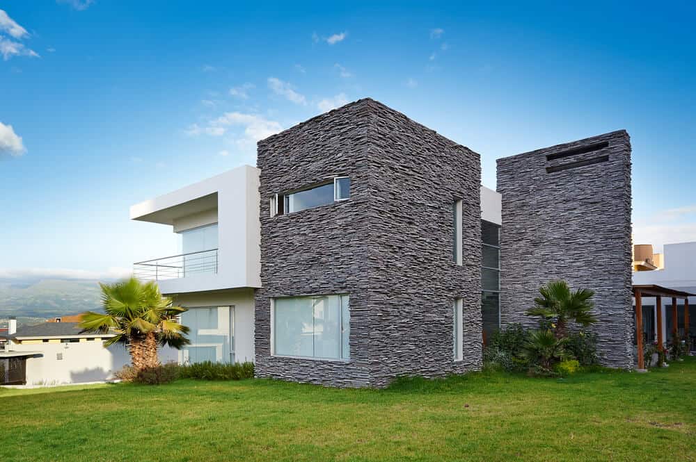 一座现代化的房子，一面由油漆混凝土制成，另一面由耐用的石头制成。