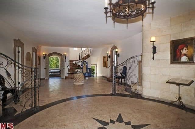 住宅的入口以优雅的地板、照明和墙壁为特色，还有一架钢琴。