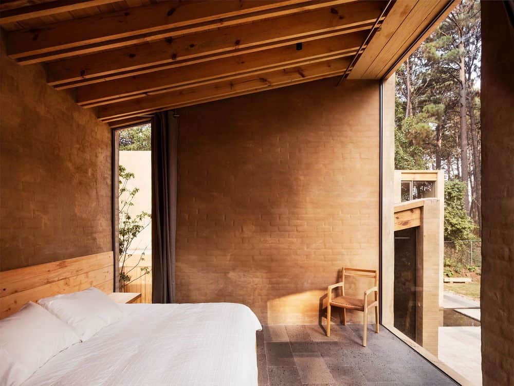主卧室有棕色砖瓦墙，以及带有裸露横梁的棚顶。