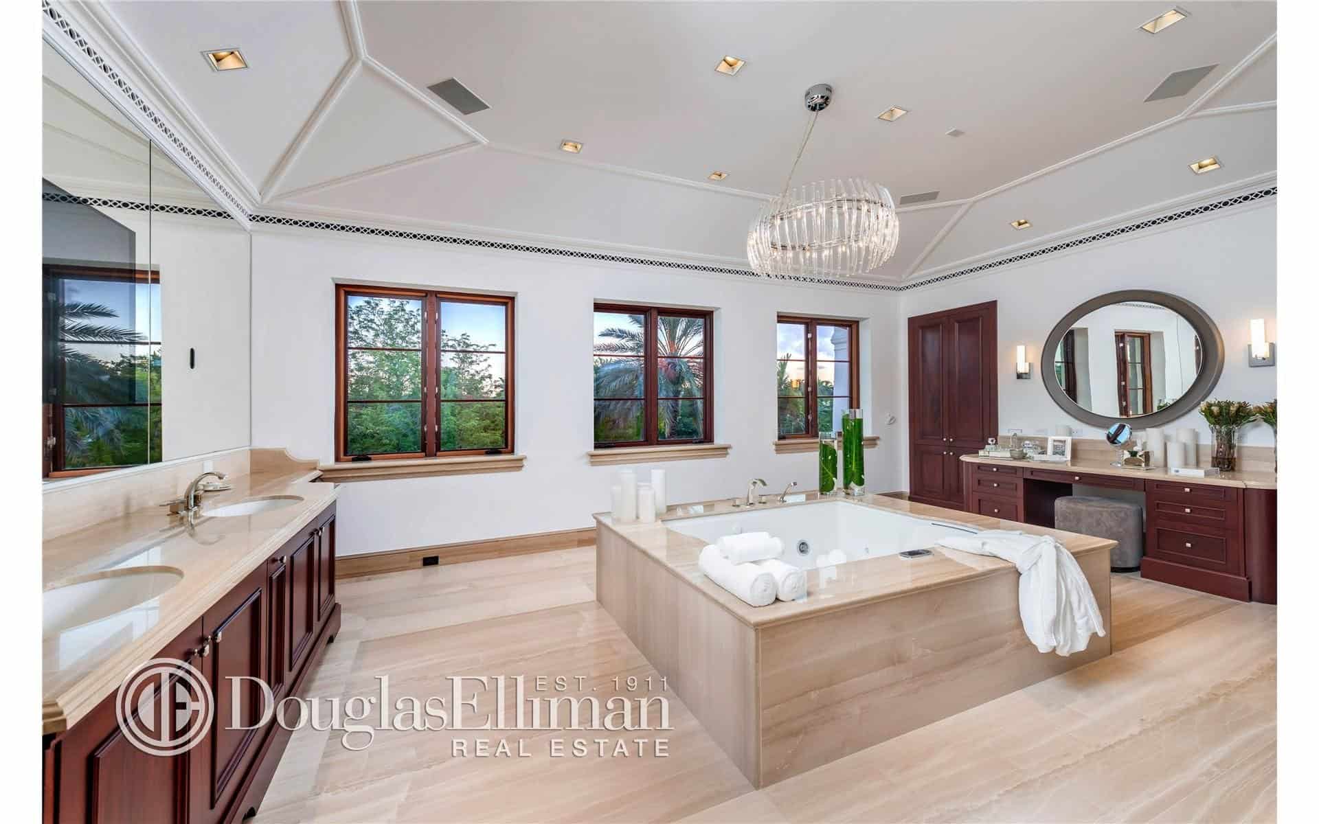 浴室有一个深浴缸，双水槽和硬木地板，由美丽的枝形吊灯照亮。