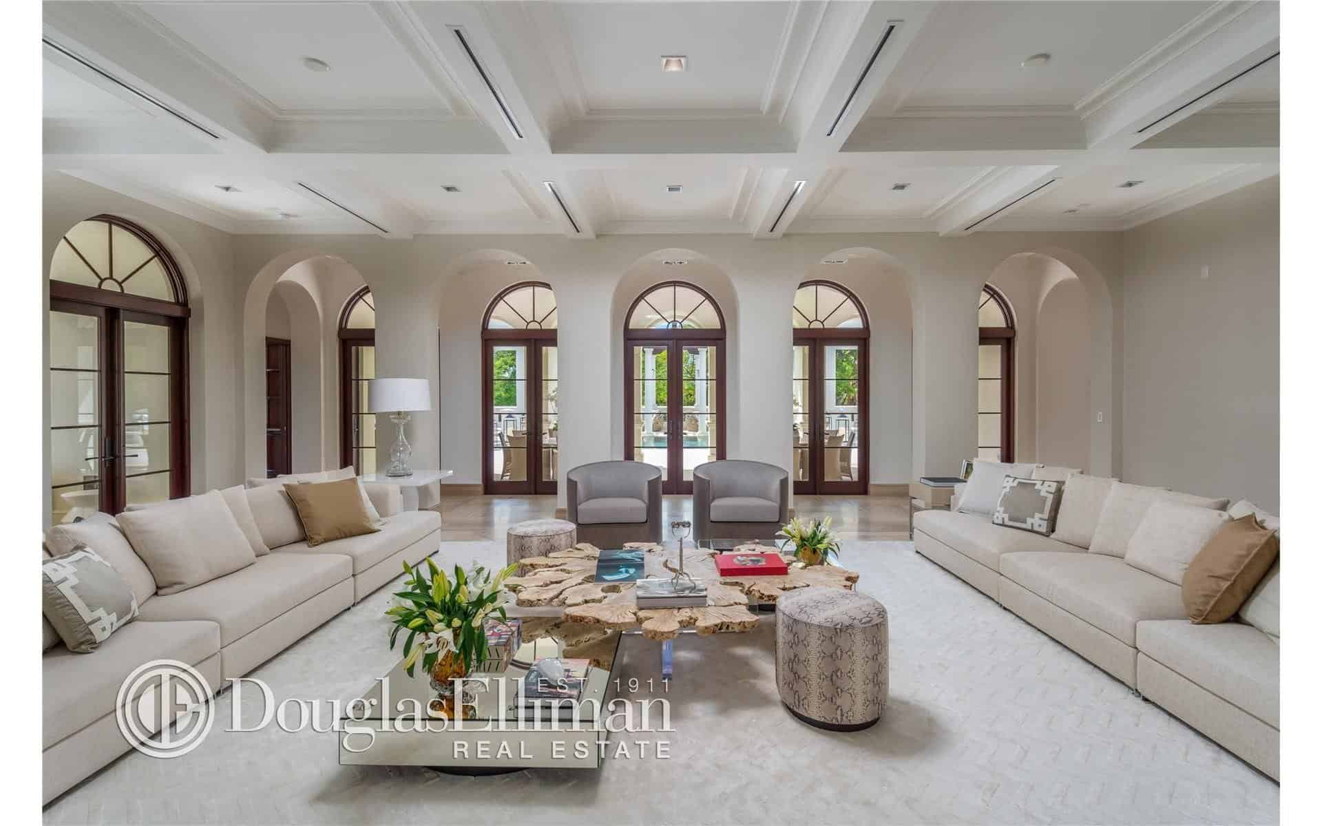 另一个客厅拥有一个巨大的空间和地毯地板，以及舒适的长对沙发和格子白色天花板。