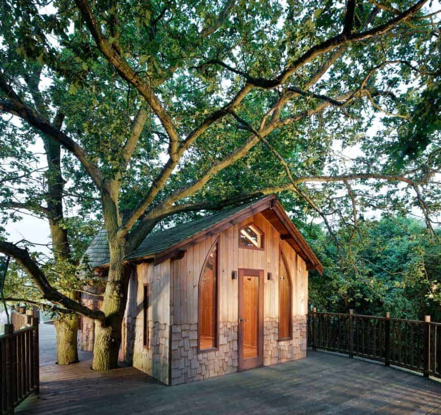 一个有趣的角落树屋，有木质外观和木质甲板。
