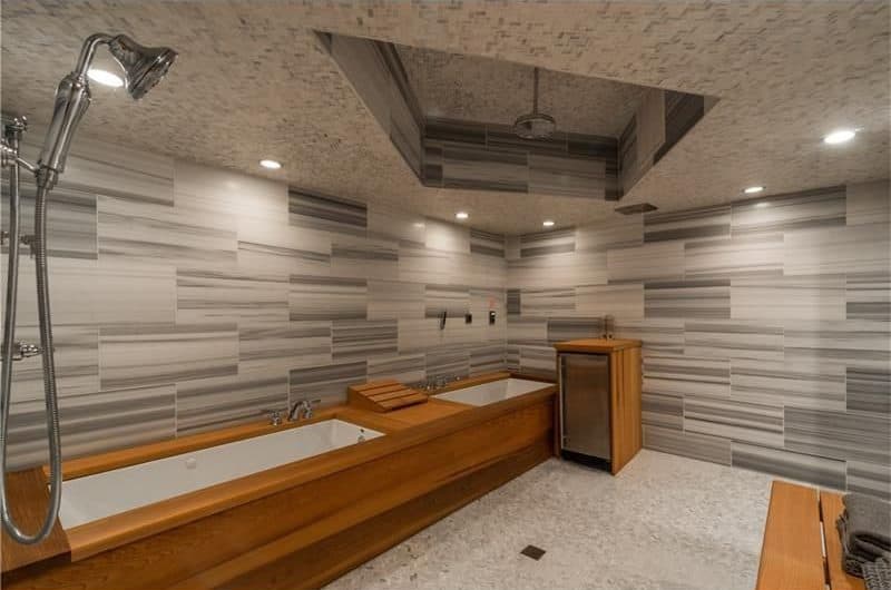浴室提供一个深泡浴缸和开放式淋浴区，以及时尚的墙壁和嵌入式天花板灯。