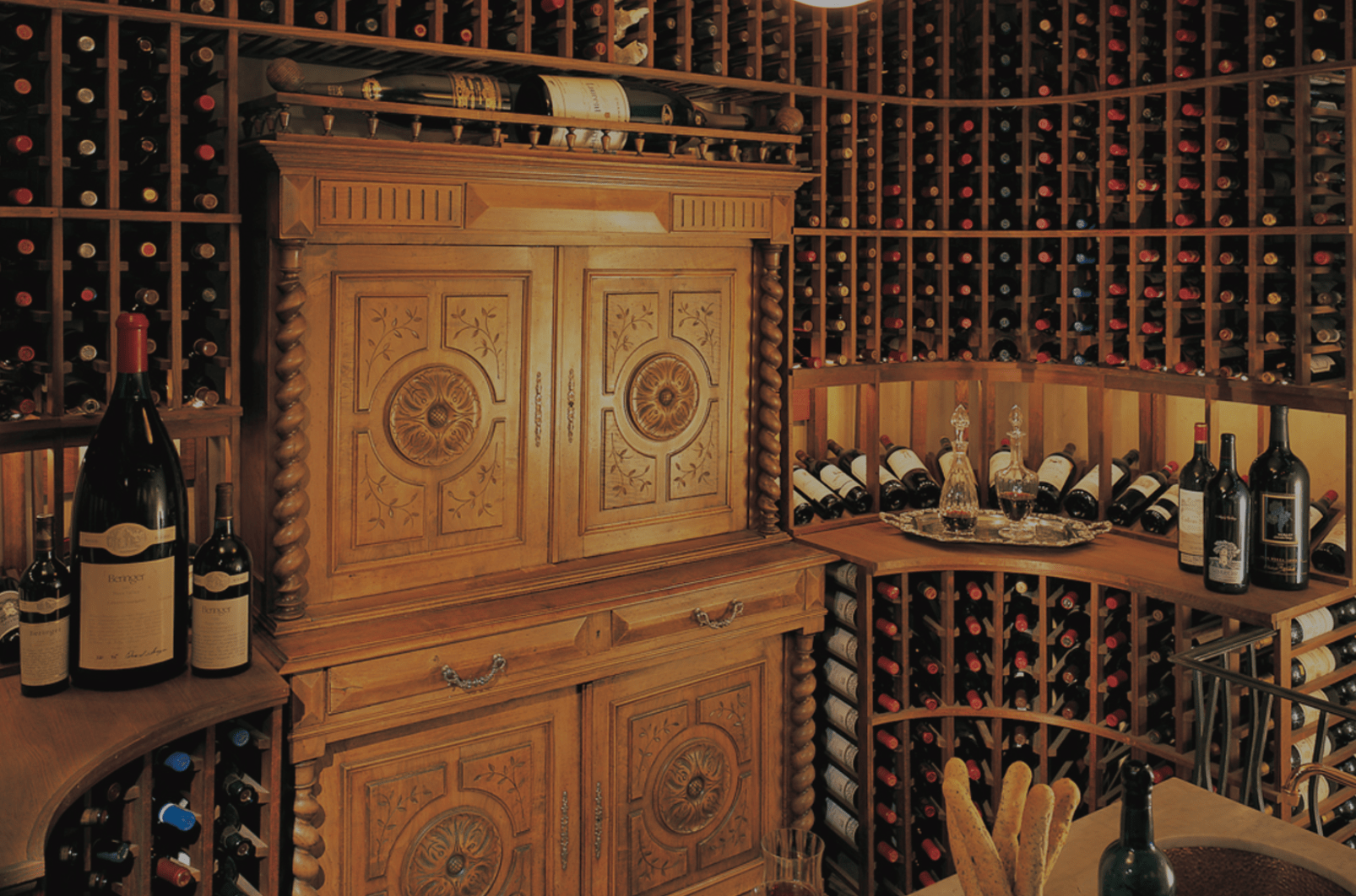 这个1400瓶的酒窖有定制的酒窖，包括角落里非常酷的弧形橱柜，头顶上的架子和品酒桌。