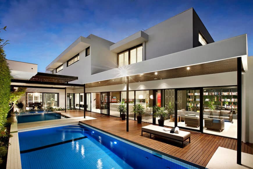 现代住宅具有灰色的外观和华丽的室外区域，带游泳池。