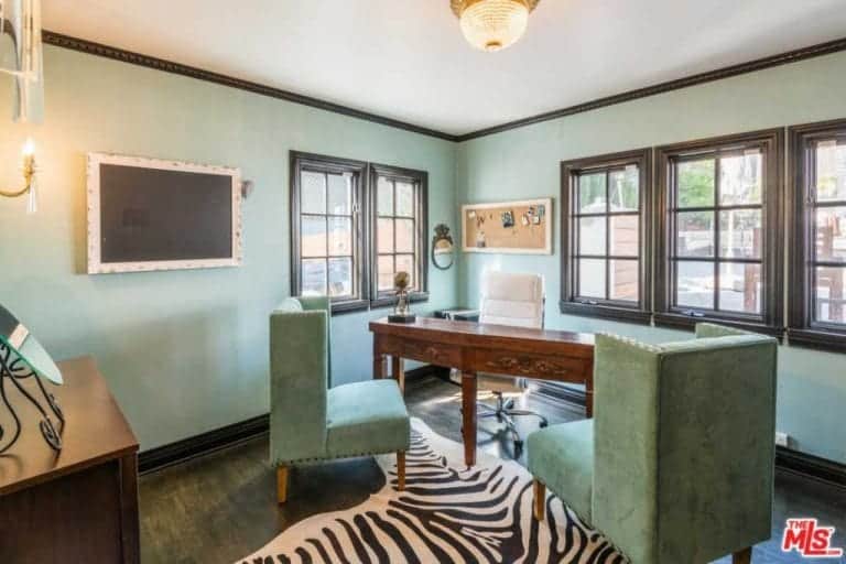 家庭办公室的特色是绿色的墙壁和座椅，硬木地板和时尚的地毯。