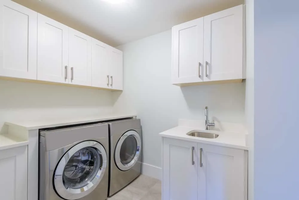 很小,但功能强大,白色洗衣房与不锈钢设备,包括一个微型下沉。