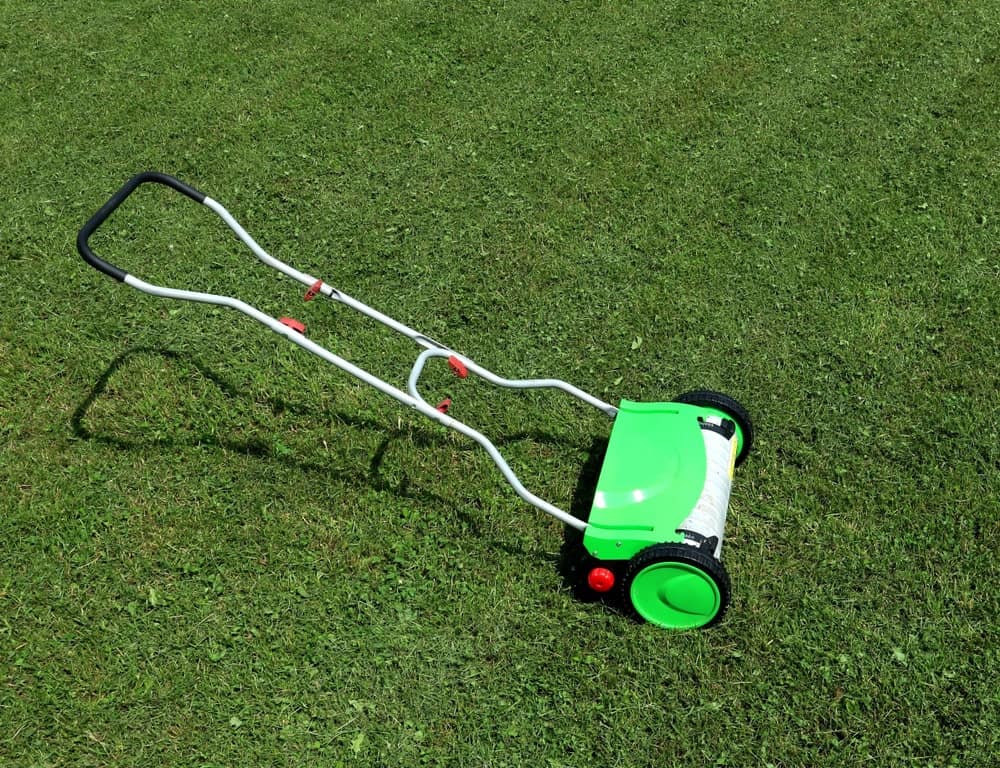 一台手动割草机停在草坪上。