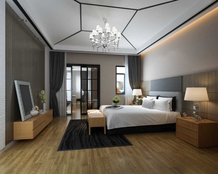宽敞的主卧室，配有现代床和时尚的吊灯，设置在令人惊叹的天花板上。
