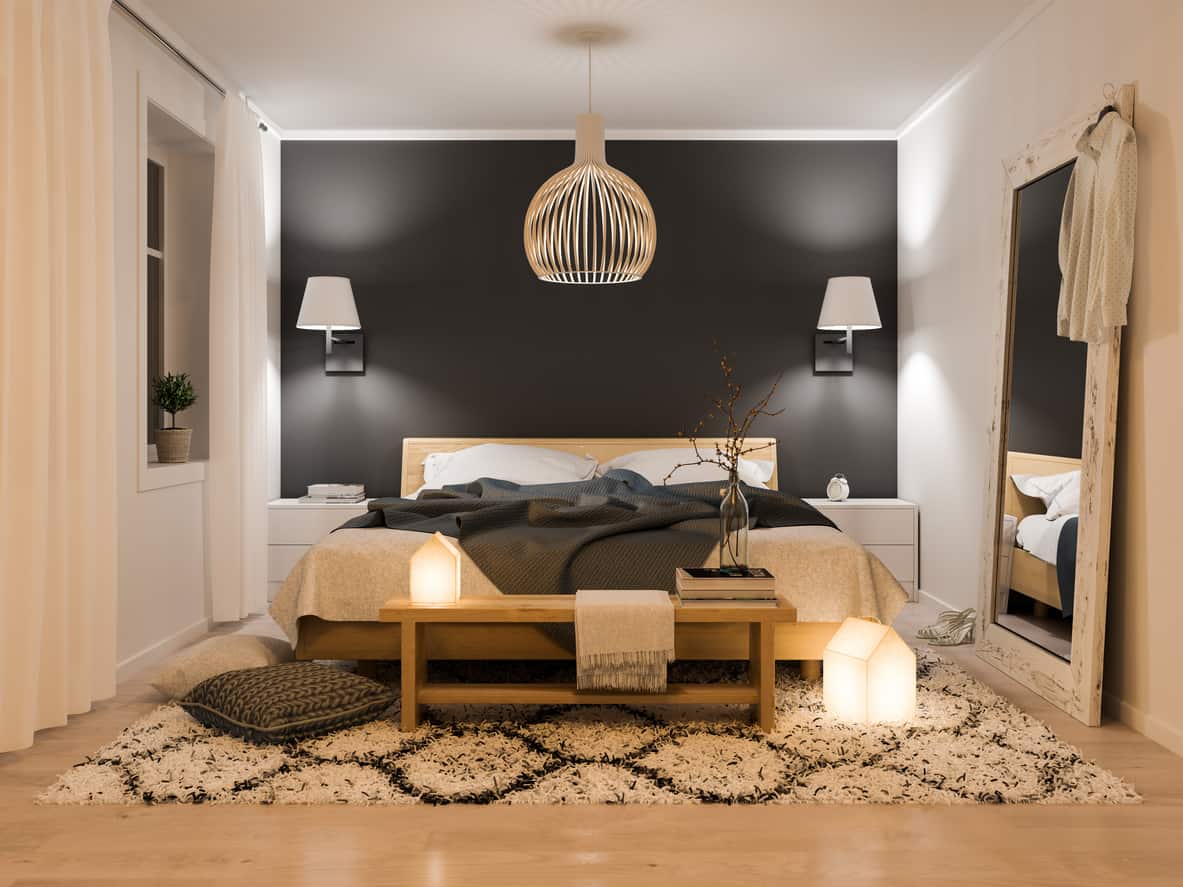 这是我最喜欢的小卧室设计之一。房间里几乎放不下一张床和两个小梳妆台床头柜，但巧妙的装饰元素让房间看起来大了很多，比如镶有白色镶边的黑色重点墙(让房间更有深度)、壁挂式灯具、带图案的区域地毯和一面大斜向镜子。小卧室的绝妙设计。