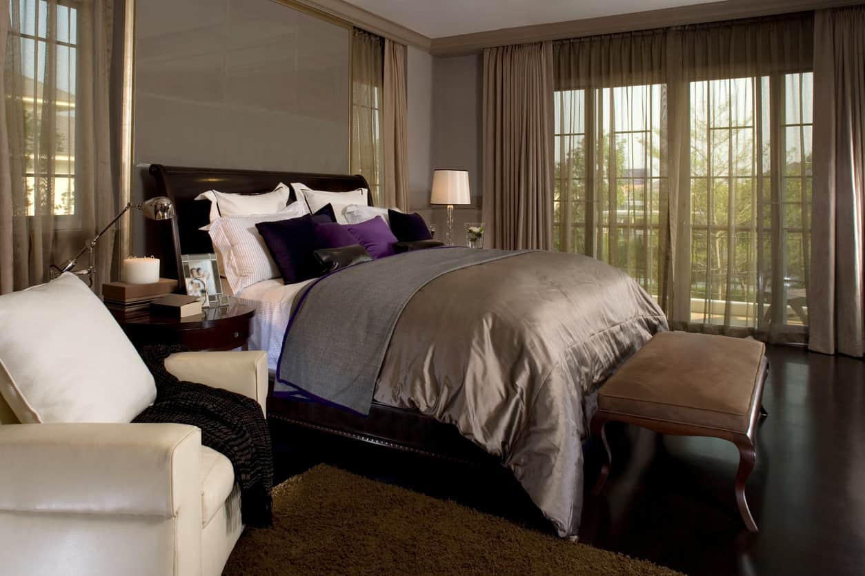 对于那些喜欢深色装饰的人来说，这里有一个在传统风格的主卧室中使用深棕色、紫色和一点白色的绝佳例子。