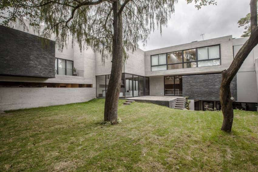 大型现代混凝土房屋，灰色饰面，以及广阔的草坪区域。