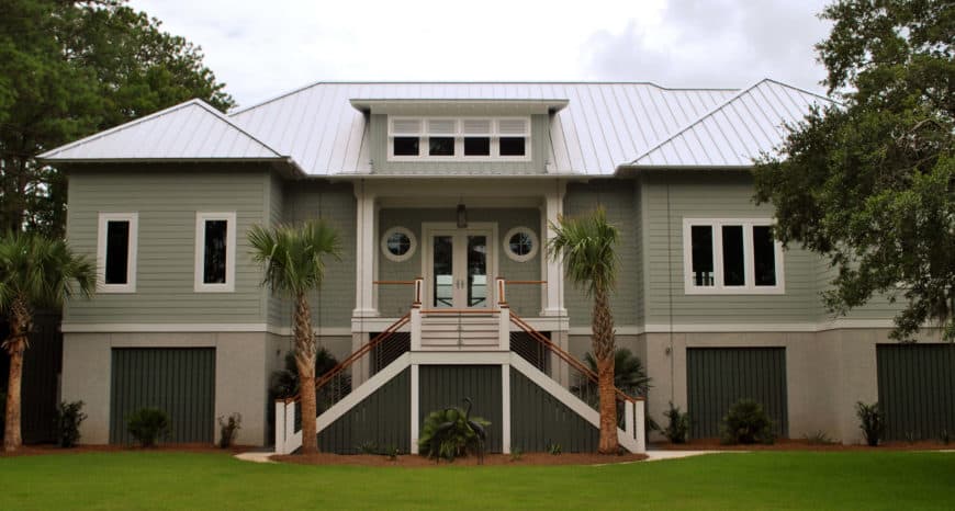 这座热带豪宅拥有灰色的外观和广阔的草坪。