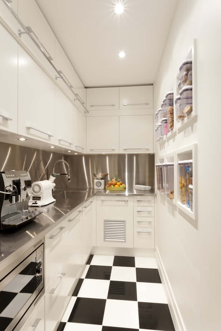 令人难以置信的白色小厨房，黑白格子地板，看看对面墙上的内置迷你食品柜……聪明的设计。室内设计师