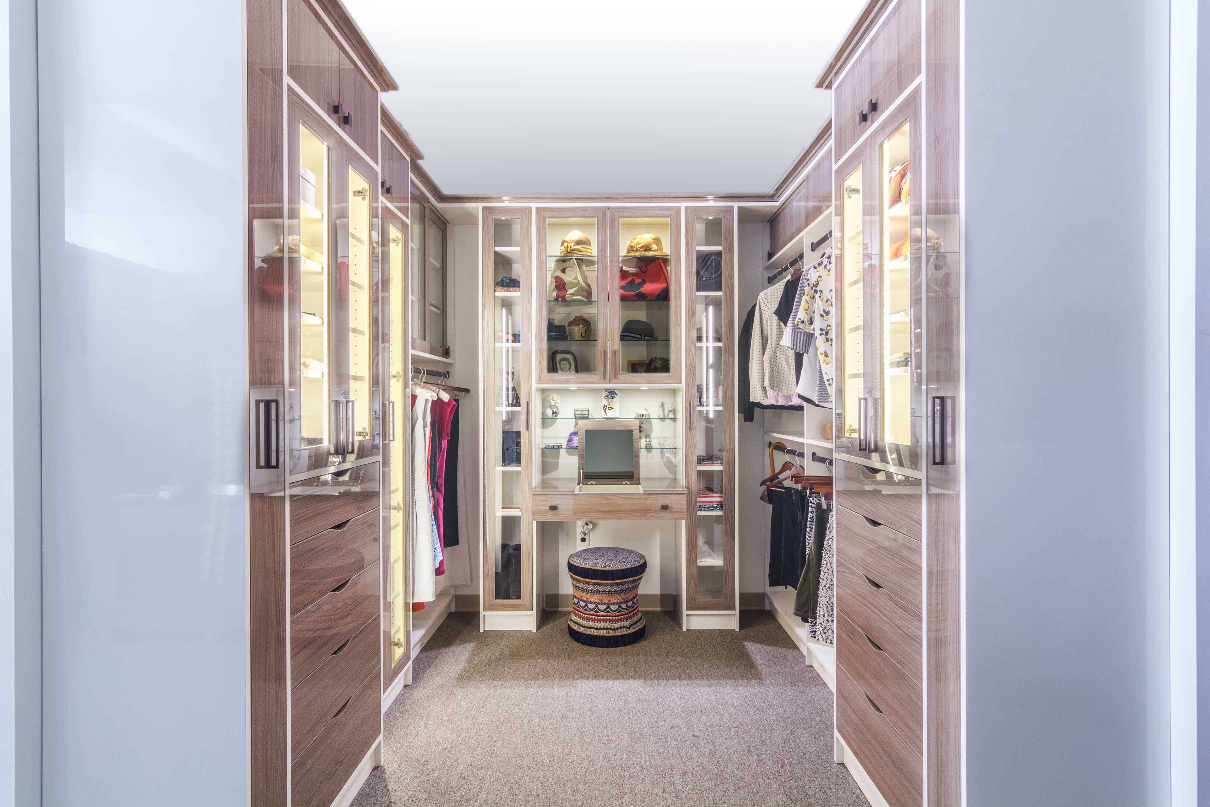 迷人的步入式衣帽间与glass-faced存储柜,内置的虚荣和大量的服装存储壁橱里工作。
